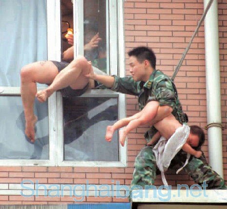 ▲ 아이를 구출한 군인이 창밖으로 뛰어내리려는 남성을 집안으로 밀고 있다.