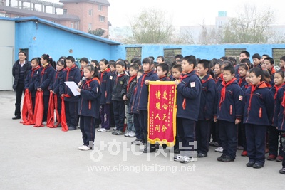 쌀 기부 전달식을 진행중인 후촨학교(沪川学校) 학생들