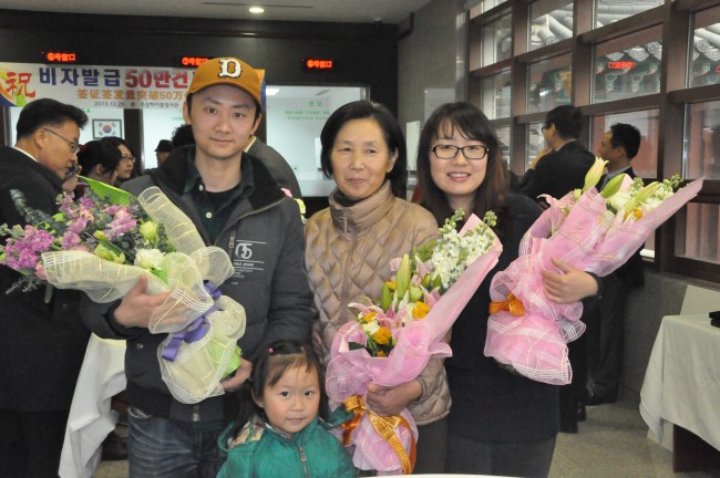 50만번째 비자신청자 장즈후이(张志慧)씨(가운데)와 그의 딸과 손녀, 그리고 50만 1번째 신청자 천펑(陈鹏)씨(좌)