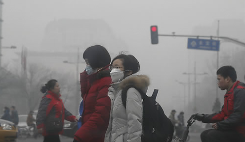 스모그로 둘러쌓인 베이징 시내를 시민들이 걷고 있다 