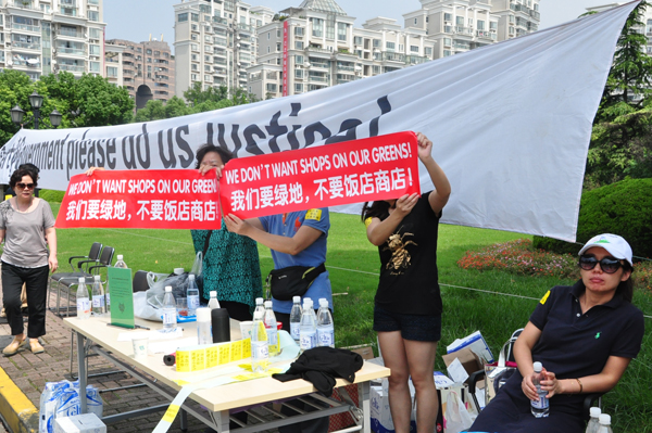 중국인 거주자들이 개발반대 플랭카드를 펼쳐 보이고 있다