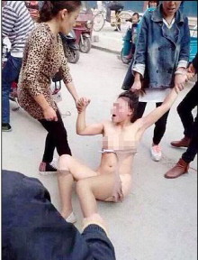 불륜 행위로 길거리에서 옷이 뜯긴채 맞고 있는 여성의 사진이 온라인에 공개됐다.