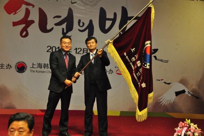 상해한국상회 깃발을 전달받은 정희천 신임회장(오른쪽)