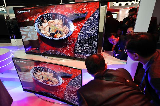 CES 2015 참관객들이 6일 중국 가전업체 창훙이 공개한 커브드 4K(UHD) TV를 꼼꼼히 살펴보고 있다.