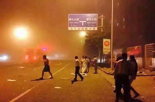 12일 중국 북부 항구도시인 톈진(天津)의 한 창고에서 폭발이 일어난 직후 놀란 사람들이 거리에 나와 있다.