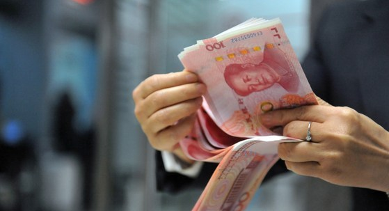 ↑ 중국 동부 저장성의 항저우 소재 은행에서 한 직원이 100위안 지폐를 세고 있다