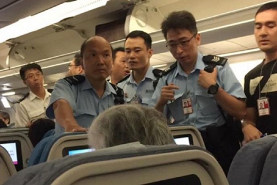 승객이 승무원에게 오렌지주스 컵을 던진 사건이 발생하자 공항에 대기 중이던 홍콩 경찰이 착륙한 비행기에 올라 조사를 하고 있다.