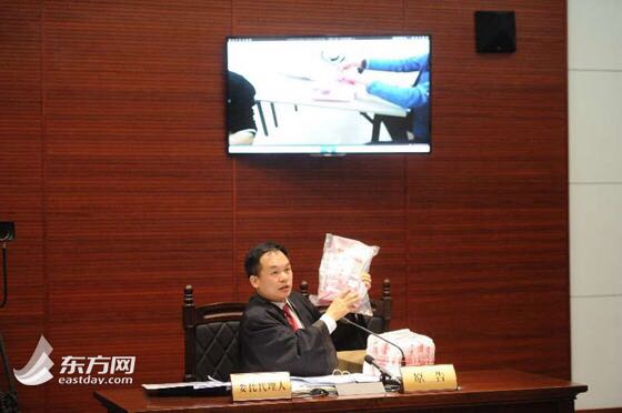 상하이 법원 1심에서 원고측 검사가 증거물을 제시하고 있다. (출처: 동방망)